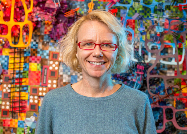 Nathalie Miebach headshot
White women, blond shoulder length hair, red glasses, wearing a grey top, in front of a colorful background.