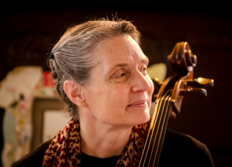 Susan Mayo headshot - white older women holding a cello. 